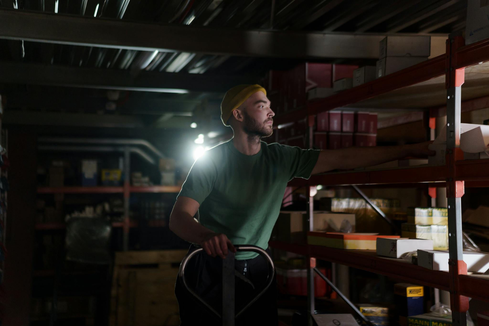 A dedicated worker organizing inventory on warehouse shelves with focused concentration.