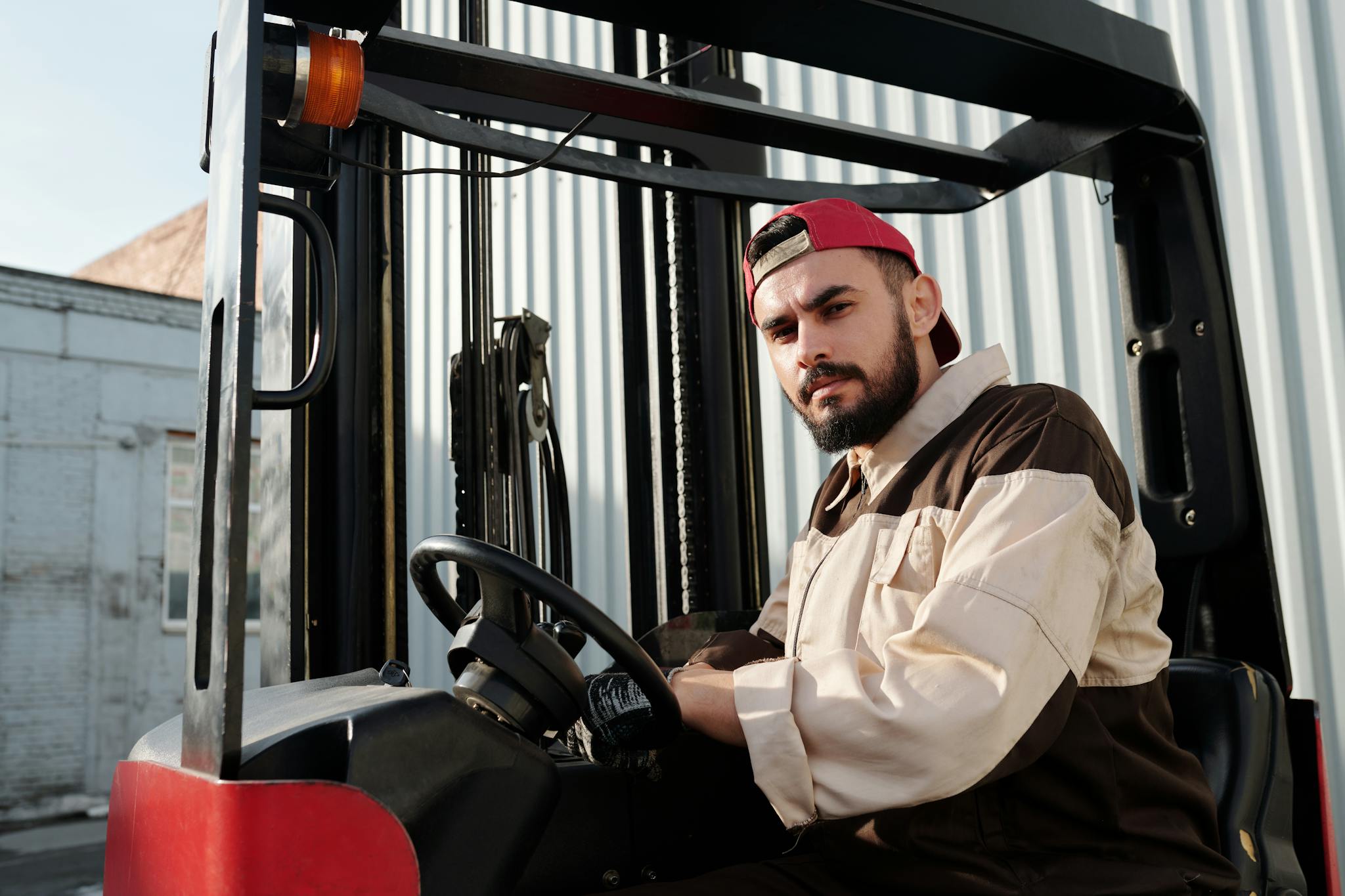 Forklift operator confidently working in an industrial outdoor environment, showcasing focus and skill.